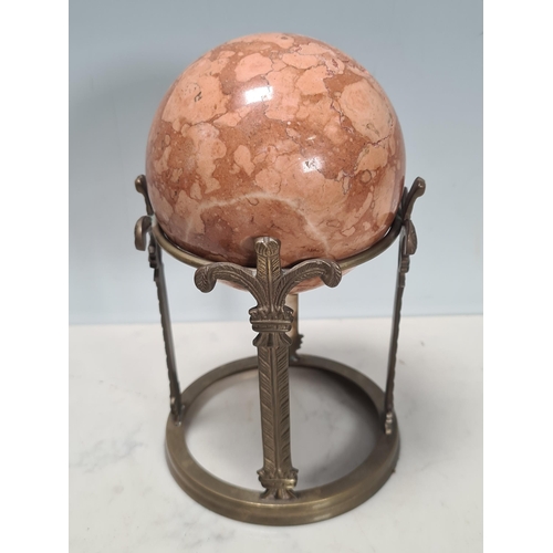 299 - A pair of marble Spheres raised on gilt metal circular supports decorated with stylised fleur-de-lys... 