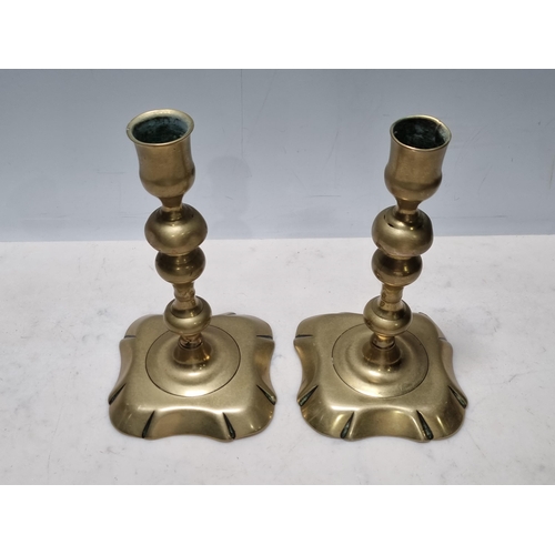 305 - A pair of 18th Century brass Candlesticks with knopped stems and shaped square bases, 6 1/2in H