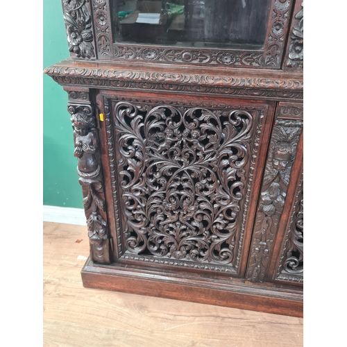 313 - A Victorian carved oak and glazed Bookcase with foliate and urn carved frieze above a pair of arched... 