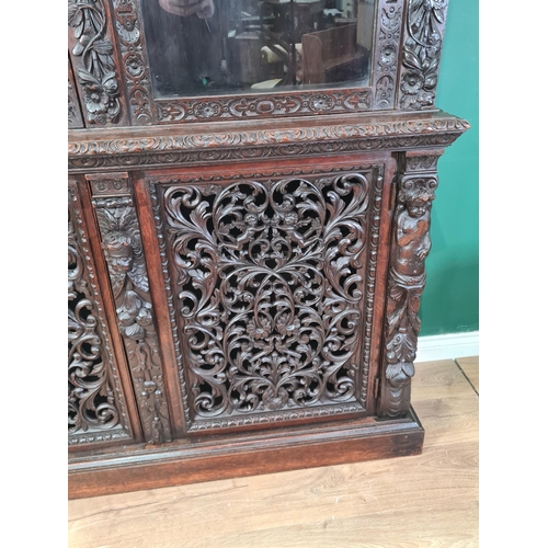 313 - A Victorian carved oak and glazed Bookcase with foliate and urn carved frieze above a pair of arched... 