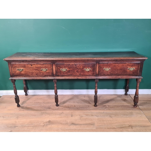 326 - An 18th century oak Dresser Base fitted with three frieze drawers and raised on six turned and squar... 