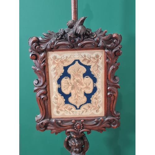 356 - A Victorian Pole Screen with woolwork panel  on carved figural support and scroll tripod base