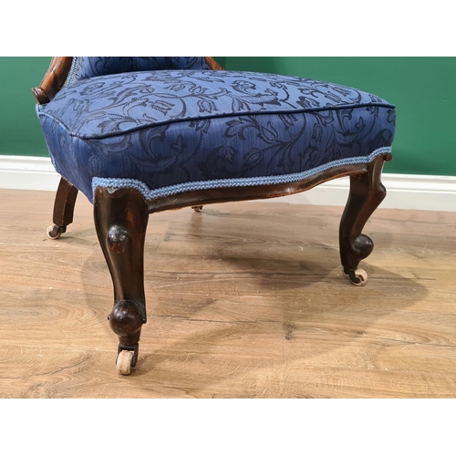 382 - A Victorian spoon back Nursing Chair with blue button upholstery on cabriole front legs and casters