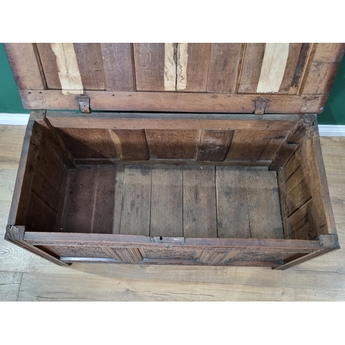 394 - A 17th Century oak Coffer, with sunken panel lid above carved scrolled frieze and carved floral deco... 