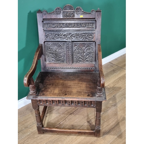 396 - A 17th Century oak open Elbow Chair with double panel back carved with thistles and named and dated ... 