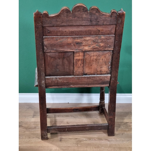 396 - A 17th Century oak open Elbow Chair with double panel back carved with thistles and named and dated ... 