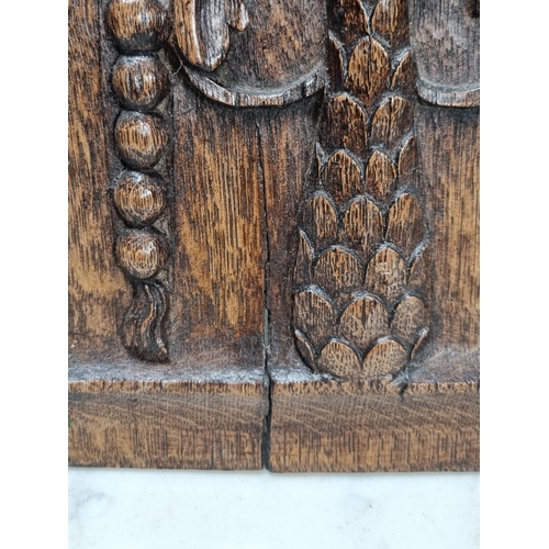 400 - A pair of 16/17th century carved oak Portrait Panels with man and woman surmounted by bird, 17 x 8in