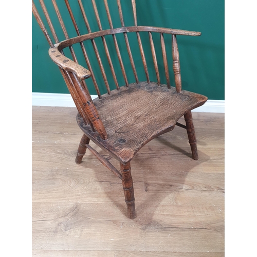 412 - A 19th Century primitive ash hoop back Elbow Chair with stick back and shaped seat raised on turned ... 