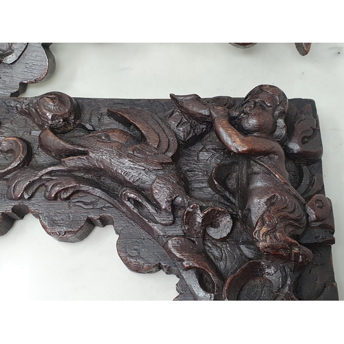 426 - A pair of 17th Century Spandrels carved with Fawns, winged Dolphin, Dog and mythical Beast amongst l... 