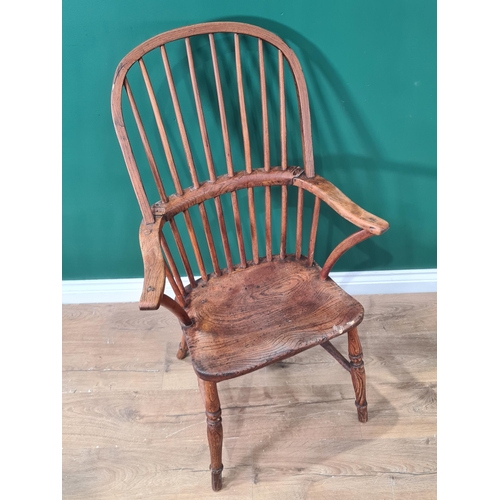 442 - A 19th century stick back Windsor Elbow Chair with solid seat on turned legs united by H stretcher