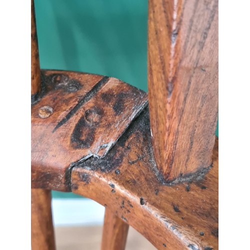 442 - A 19th century stick back Windsor Elbow Chair with solid seat on turned legs united by H stretcher