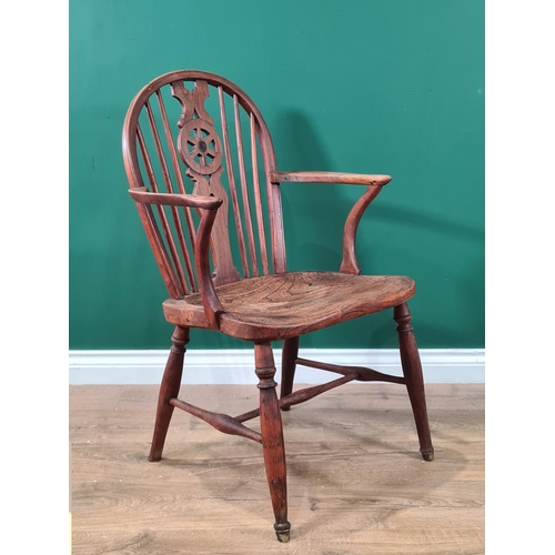 444 - A 19th century Windsor Elbow Chair of small proportions with wheelback, solid seat on turned legs un... 