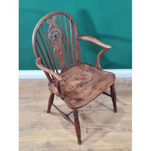 444 - A 19th century Windsor Elbow Chair of small proportions with wheelback, solid seat on turned legs un... 