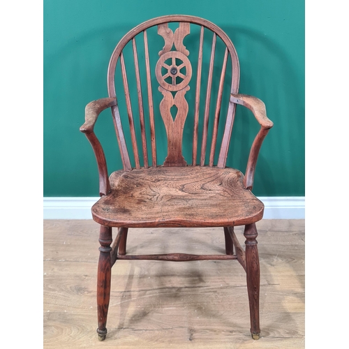 444 - A 19th century Windsor Elbow Chair of small proportions with wheelback, solid seat on turned legs un... 