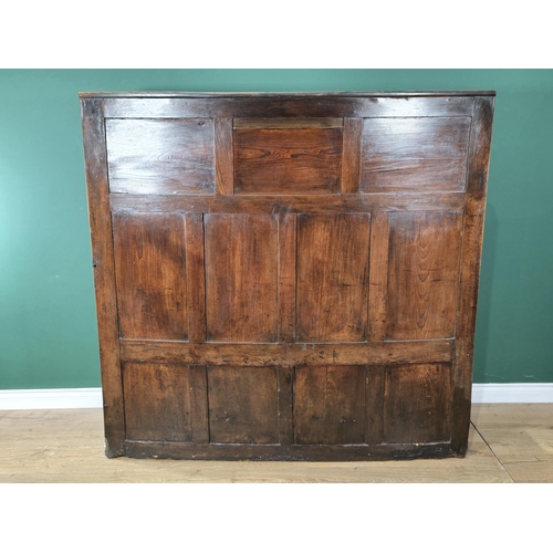 469 - An 18th Century carved oak Wingback Settle with seven fielded panels to the back and the base, fitte... 