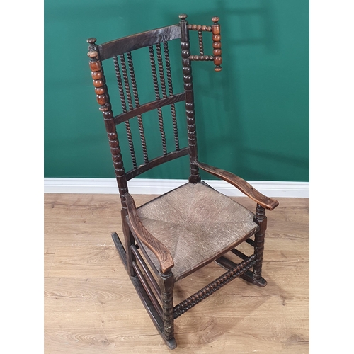 471 - A bobbin-turned Rocking Chair in the manner of Ernest Gimson, with bobbin wingback, spindle back, ru... 