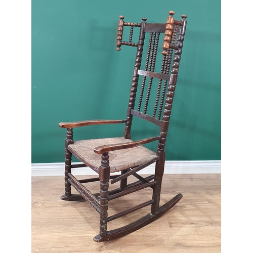 471 - A bobbin-turned Rocking Chair in the manner of Ernest Gimson, with bobbin wingback, spindle back, ru... 