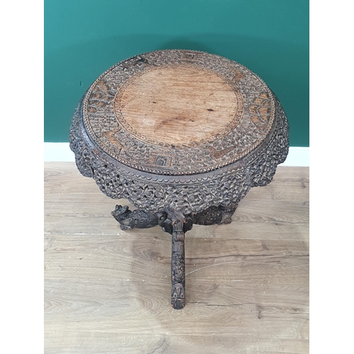 474 - A heavily carved Burmese Padouk Centre Table, the circular top with animal and leafage decoration an... 