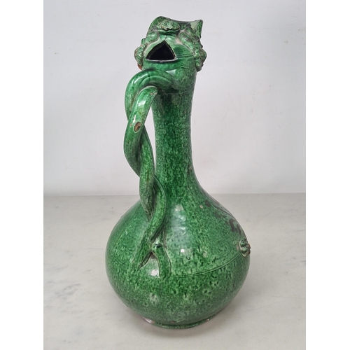 538 - A 19th century ottoman empire canakkale pottery Ewer in green glaze with applied moulded floral deco... 