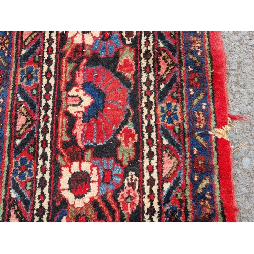 655 - A large Persian woollen Carpet with central cream diamond shaped flower head within red ground with ... 