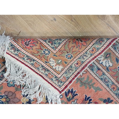 660 - A bordered Persian Rug, the central ground with floral motifs on a pale red ground, 4ft 7in x 3ft 1i... 