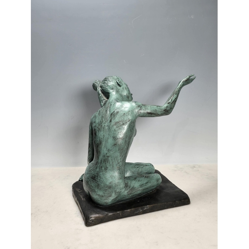 686 - ? CORBOULD; a resin Figure of a seated nude female with one hand held up on square base, 12in H, sig... 