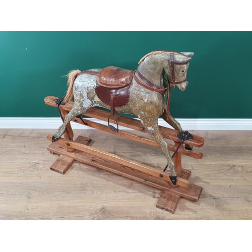 690 - An antique carved and painted Rocking Horse, overpainted, including saddle and stirrups, and mounted... 