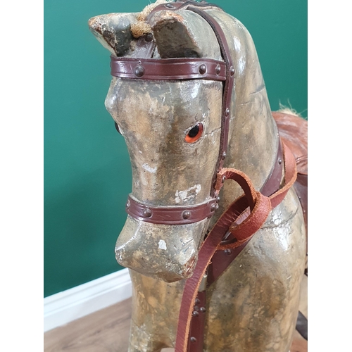 690 - An antique carved and painted Rocking Horse, overpainted, including saddle and stirrups, and mounted... 