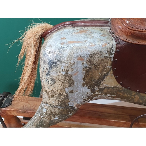 690 - An antique carved and painted Rocking Horse, overpainted, including saddle and stirrups, and mounted... 