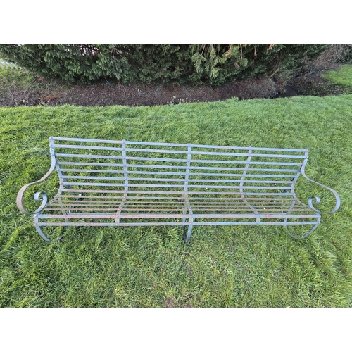 701 - A large green painted riveted strapwork iron Garden Bench with shaped seat, scrollwork arms and supp... 