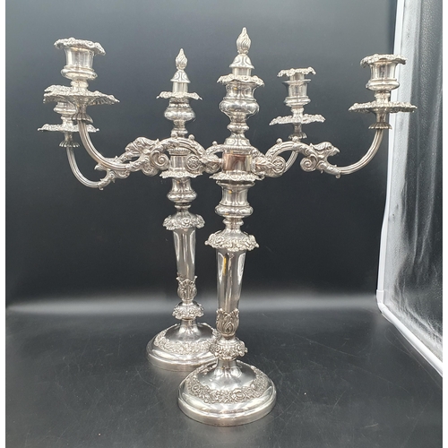 78 - A pair of 19th century Sheffield plated Candlesticks with foliate friezes fitted two branch surmount... 