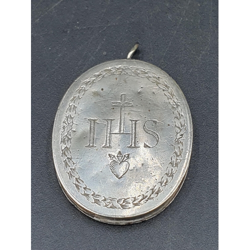 87 - An oval white metal Pendant engraved crown over initials MAR and heart, opening to reveal rolled pap... 