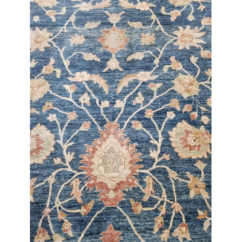 657 - A bordered Oriental Carpet, the central field with palmettes and trailing branches on a blue ground,... 