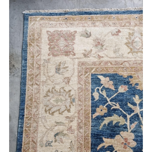 657 - A bordered Oriental Carpet, the central field with palmettes and trailing branches on a blue ground,... 