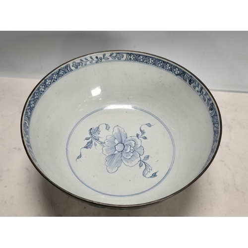 835 - A Chinese export blue and white Bowl depicting floral sprays, metal rim. Kangxi, carved wooden stand... 