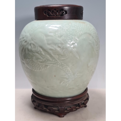 811 - A rare Chinese carved celadon dragon Jar. The bulbous body carved with a writhing 4 claw dragon chas... 