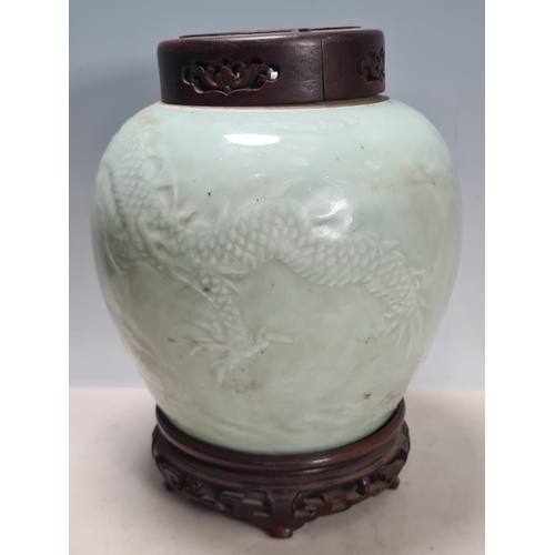 811 - A rare Chinese carved celadon dragon Jar. The bulbous body carved with a writhing 4 claw dragon chas... 