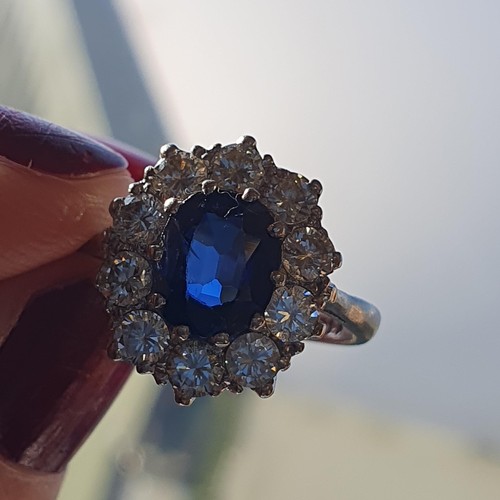 160 - A mid-century Sapphire and Diamond Cluster ring, claw-set oval mixed-cut sapphire, surrounded by ten... 