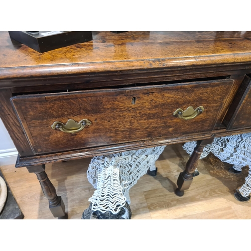 326 - An 18th century oak Dresser Base fitted with three frieze drawers and raised on six turned and squar... 