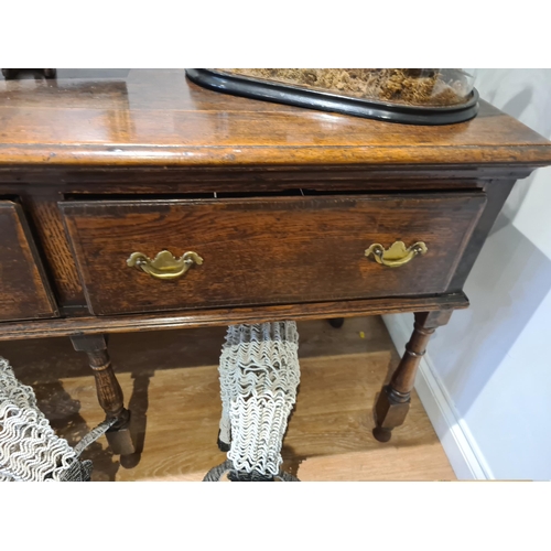 326 - An 18th century oak Dresser Base fitted with three frieze drawers and raised on six turned and squar... 