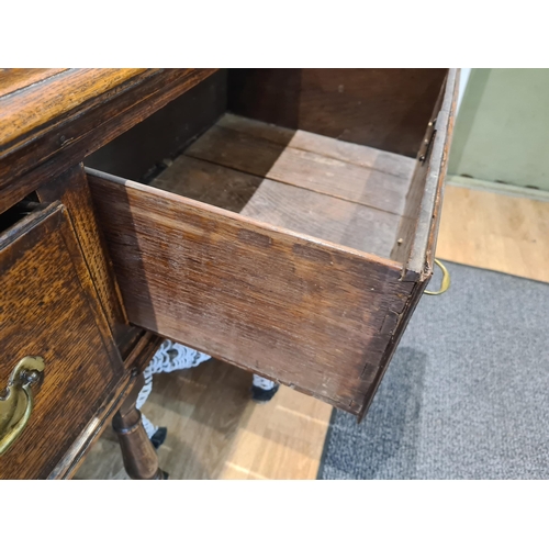 326 - An 18th century oak Dresser Base fitted with three frieze drawers and raised on six turned and squar... 