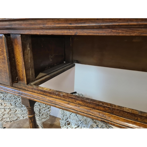 326 - An 18th century oak Dresser Base fitted with three frieze drawers and raised on six turned and squar... 