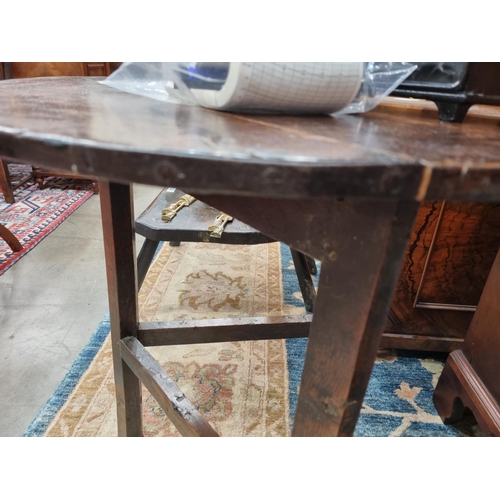 365 - An 18th Century oak Cricket Table with circular top on three triangular supports united by stretcher... 