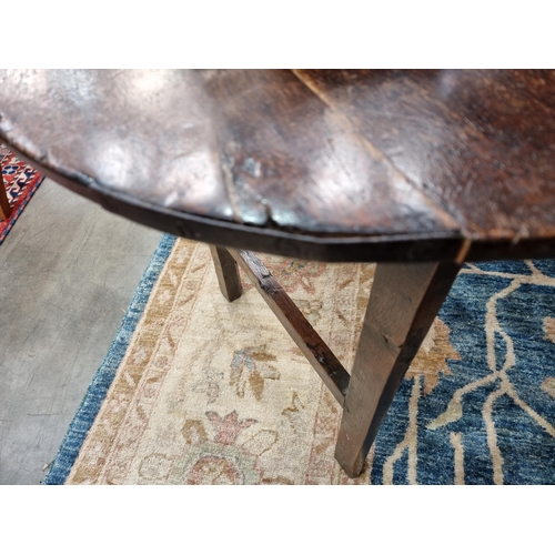 365 - An 18th Century oak Cricket Table with circular top on three triangular supports united by stretcher... 