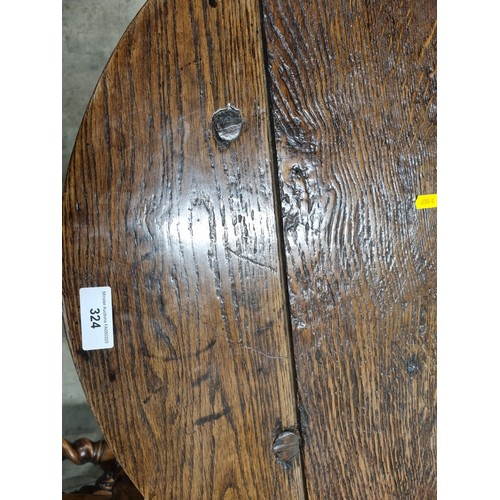 324 - A 19th Century oak Cricket Table, the circular top above turned column and an undertier, raised on t... 