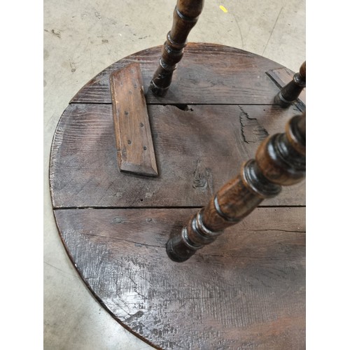 324 - A 19th Century oak Cricket Table, the circular top above turned column and an undertier, raised on t... 