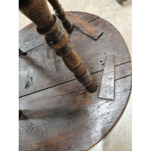 324 - A 19th Century oak Cricket Table, the circular top above turned column and an undertier, raised on t... 