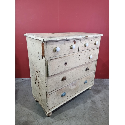 14 - A cream painted pine Chest of two short over three long graduated Drawers, raised on turned bun feet... 
