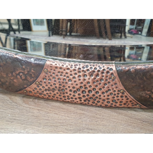 24 - An oval copper framed Wall Mirror with applied shell type roundel decorations with bevelled plate, b... 