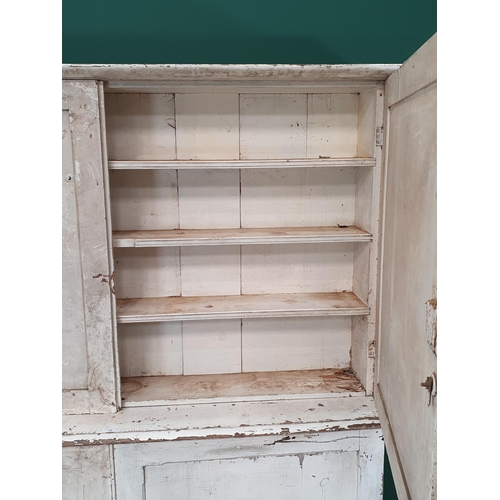 25 - A white painted pine two piece Pantry Cupboard, the top with moulded cornice above pair of panelled ... 